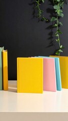 Colorful books line shelf under trailing green plant