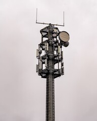 Telecommunication tower reaching for the cloudy sky, broadcasting signals