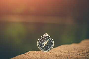 Compass resting on the shoreline, guiding the journey toward the glowing horizon.