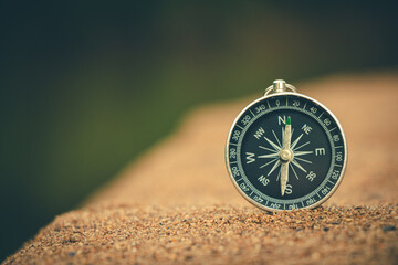 Classic compass rose lying on warm sand, symbolizing exploration and the beauty of the journey.