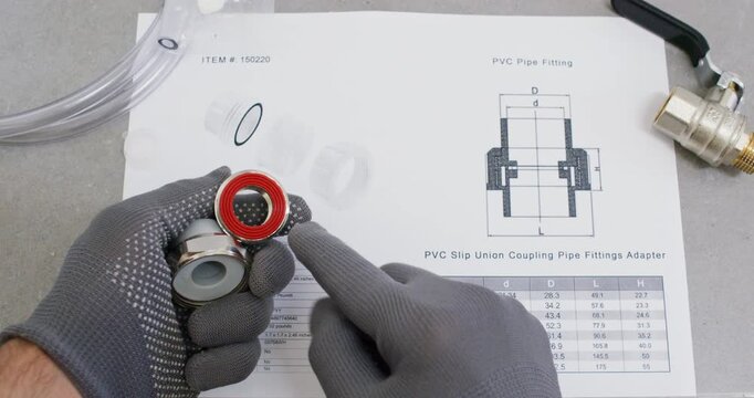 Technician shows union fitting parts over schematic sheet. Plumber separates cap nut and ferrule showing gasket ring with notes orientation for correct assembly