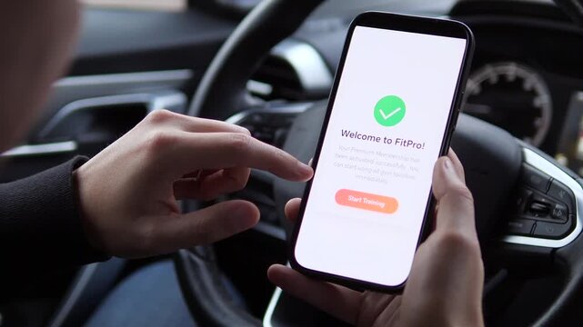 Closeup of a mans hands in a parked car reading a confirmation message for a newly activated gym membership on his phone. This clip embodies the moment of committing to a healthier lifestyle and the