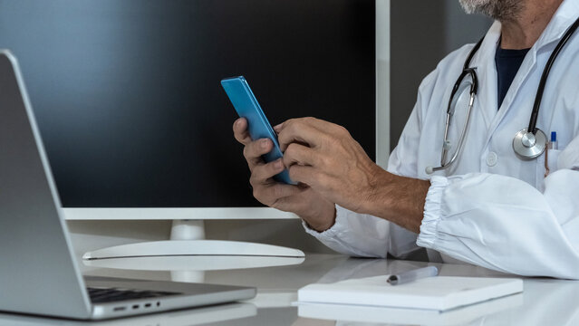 Doctor engaging with a smartphone in a modern medical setting, seamlessly integrating digital tools into patient care