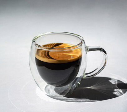 Rich Espresso Coffee in Double-Walled Glass Mug on Minimalist Grey Background with Shadows - Powered by Adobe