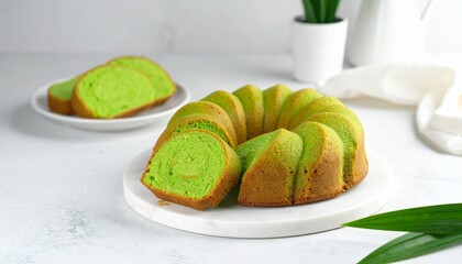 Traditional Indonesian pandan sponge cake with vibrant green slices on a marble board