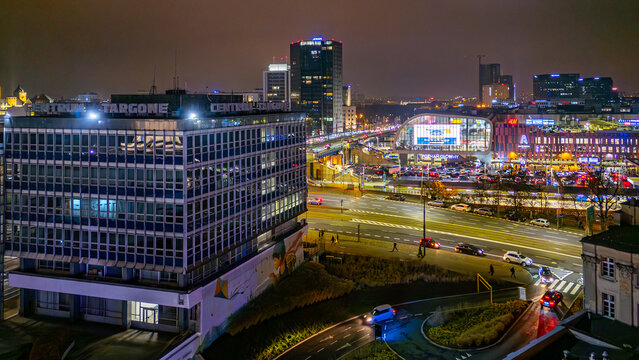 Night drone view of MTP Trade Center and Avenida near Poznan Glowny station showing heavy city traffic across the illuminated central area