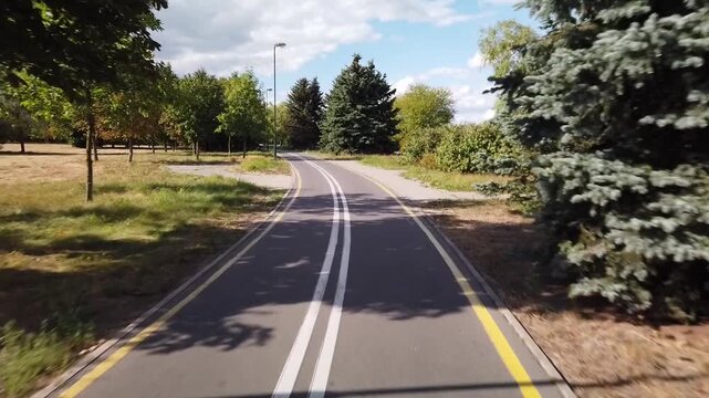 Serene bike pathway through lush green parklands
 - Powered by Adobe