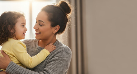 Celebrating Adoption Month with loving embrace between mother and child. This tender Adoption Month moment captures warmth of family, as smiling mother holds curly haired daughter in sunlight.