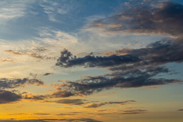 Stunning sunset over the horizon with vibrant colors and dynamic cloud formations at twilight in a tranquil outdoor setting