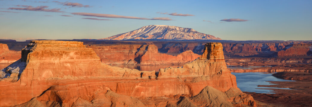 This Lake Powell sunset panorama features a zoomed in view of Gunsight Butte and rising above, snow covered Navajo Mountain.

