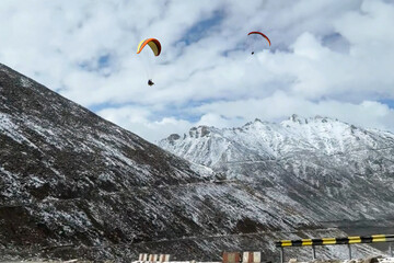 Tourists paragliding 3 pm 6 june 2025 at Leh Ladakh with view of Himalayan mountain range.