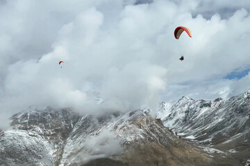 Tourists paragliding 3 pm 6 june 2025 at Leh Ladakh with view of Himalayan mountain range.