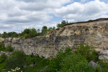 Cliffside landscape with lush greenery and cloudy sky during daytime near a natural park