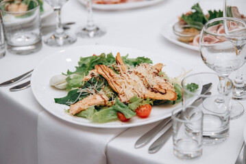 Caesar salad in plate on white table in banquet hall