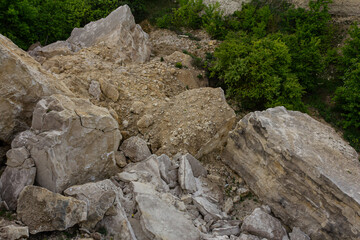 Rocky terrain showcases a blend of rugged stones and lush green vegetation along a hillside during daylight