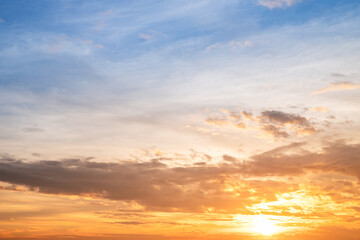 Sunset or sunrise sky with a vibrant gradient of orange, gold, and soft blue. Clear atmosphere with wispy clouds. Peaceful, natural light background. hope, freedom, new day and inspirational Concepts