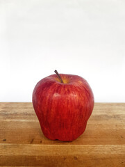 Close-Up of Ripe Red Gala Apples with Stems, white and wood background