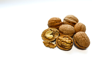 Whole and peeled brown walnuts on the white background