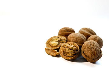 Whole and peeled brown walnuts on the white background