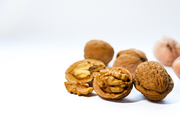 Whole and peeled brown walnuts on the white background