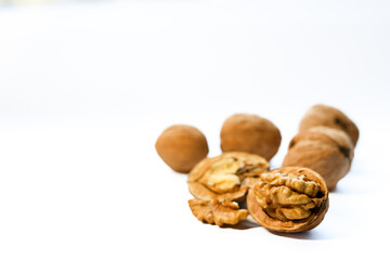 Whole and peeled brown walnuts on the white background