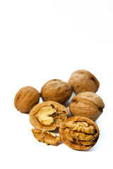 Whole and peeled brown walnuts on the white background