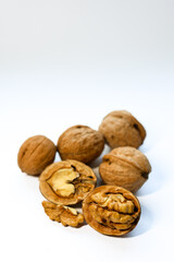Whole and peeled brown walnuts on the white background