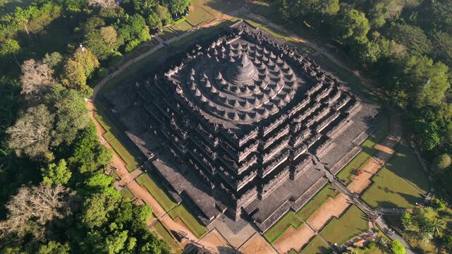 Aerial view of Borobudur Temple in Central Java, Indonesia. Ancient Buddhist monument at sunrise, surrounded by tropical jungle. UNESCO World Heritage Site, culture, history, and travel themes.