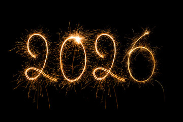Happy New Year 2026. Burning sparkling text 2026 isolated on black background.