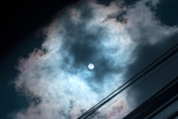Bright Sun Covered by Clouds and Power Lines. Sun with Cloudy sky dramatic photography
