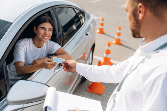 Congratulations giving the license, passed. Woman is trying to pass exam in the driving school