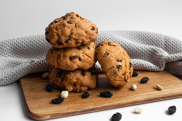 Stack cookies with scattered raisins and nuts. Homemade baked goods on light background. For food blogs, bakery ads and recipe content.