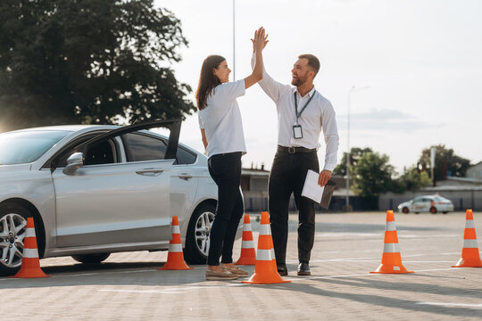 High five, you passed. Woman is trying to pass exam in the driving school
