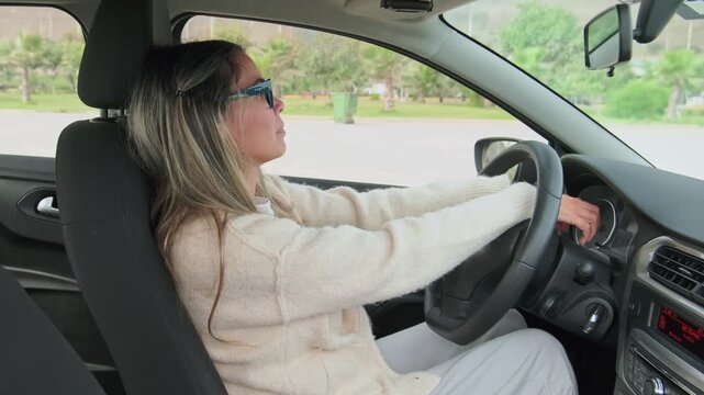 Teenage girl feeling nervous and scared during her first driving lesson in an empty parking lot