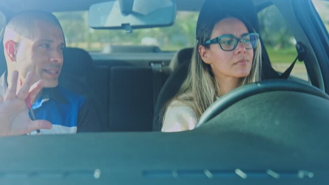 Female student learning to drive a car with her instructor in the passenger seat