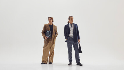 Two stylish male professionals posing confidently in modern tailored office outfits. Concept of business identity, fashion editorial aesthetics, and contemporary leadership image.