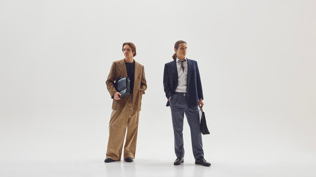 Two stylish male professionals posing confidently in modern tailored office outfits. Concept of business identity, fashion editorial aesthetics, and contemporary leadership image.