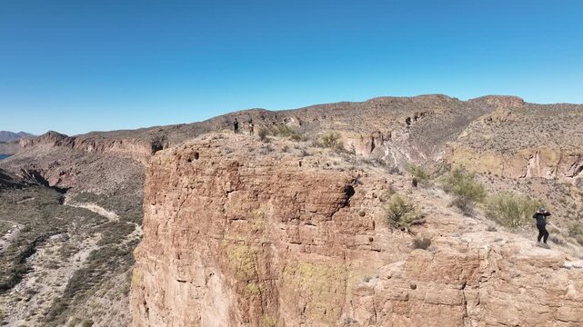 Aerial view of rocky cliffs with sparse vegetation under a clear sky, displaying the arid beauty, Apache Junction, Arizona, United States.