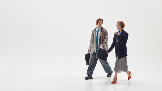 Male and female colleagues walking and discussing ideas representing teamwork and innovation. Concept of collaboration, equality, and business communication in modern workplace culture.