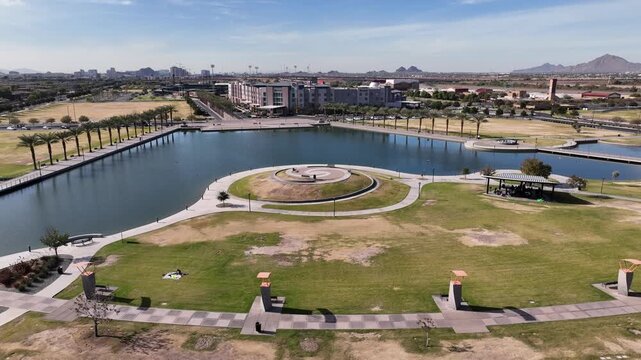 Aerial view of Riverview Park showing a serene lake reflecting the clear sky, surrounded by lush green spaces, Mesa, Arizona, United States.