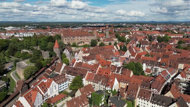 Aerial view of Nuremberg's red rooftops and the imposing Nuremberg Castle amidst the city's ancient walls, a vibrant contrast against the blue sky, Nuremberg, Bavaria, Germany.