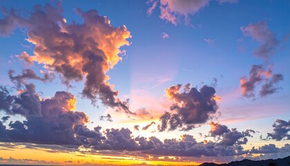 Stunning photo captures a vibrant sunset with puffy clouds illuminated by the golden rays of the setting sun. The blue sky creates a contrasting background