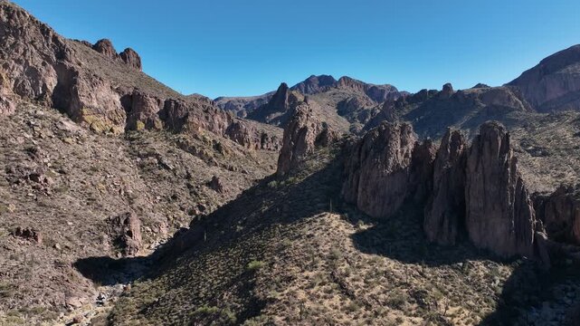 Aerial view of the rugged Superstition Mountains, a landscape of stark rock formations and sparse vegetation, showcasing nature's raw beauty, Apache Junction, Arizona, United States.