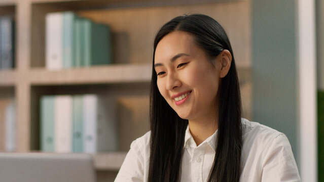 Happy laughing Asian Korean businesswoman female office worker excited amazed Japanese Chinese business woman entrepreneur looking laptop device celebrating online winning victory prize triumph indoor