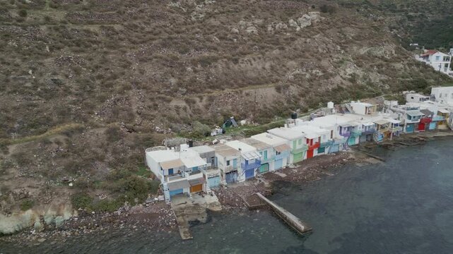 Aerial view of the picturesque village of Klima with its vibrant, colorful buildings nestled along the coast, Klima, Milos, Greece.