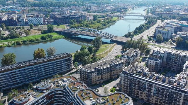 Aerial drone view of modern Wisla Terraces residential buildings in Krakow, Poland, featuring contemporary architecture and unique green roofs near the Vistula River.