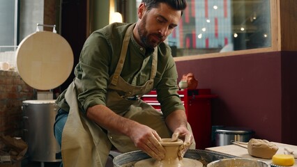 Happy relaxed creative Caucasian man male guy small business owner craftsman potter businessman making pottery clay spinning wheel crockery looking camera showing thumb up raise finger indoor workshop