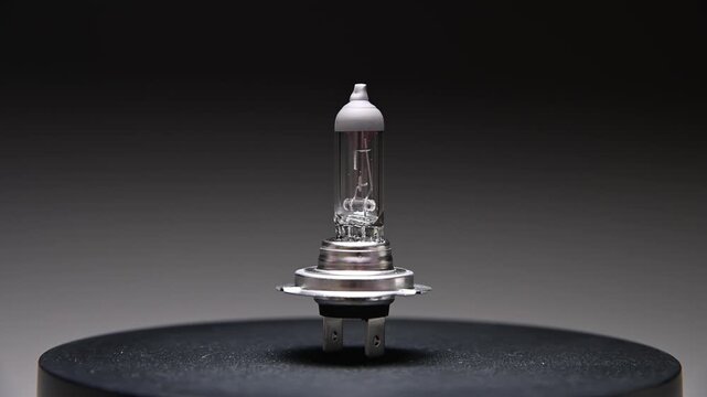 A new spare part rotates on a black gradient background. A car light bulb.