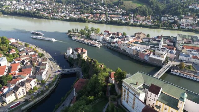 Aerial view of the confluence of rivers meeting at the fortress, the townscape a tapestry of terracotta roofs and pastel buildings, Passau, Bavaria, Germany.