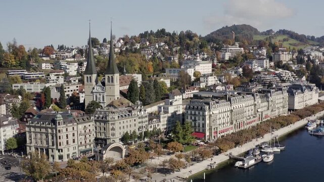 Aerial view of the Hofkirche towers rising above the city, with boats dotting the serene waters of lake lucerne, lucerne, lucerne, Switzerland.